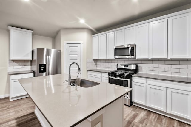 kitchen featuring white cabinetry, sink, stainless steel appliances, and a center island with sink