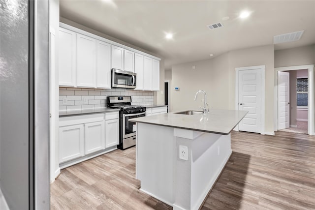 kitchen featuring white cabinetry, sink, light hardwood / wood-style flooring, a center island with sink, and appliances with stainless steel finishes