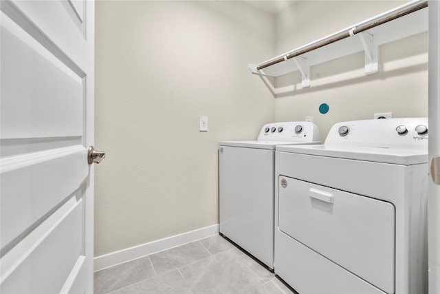 laundry room with washer and clothes dryer and light tile patterned floors