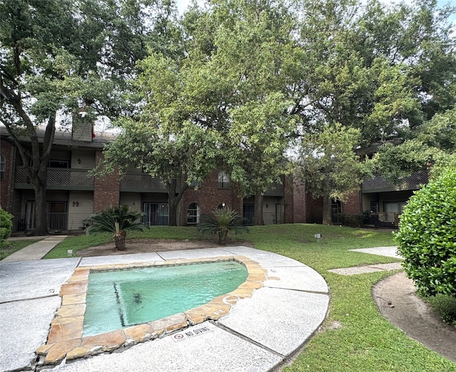 view of swimming pool with a lawn