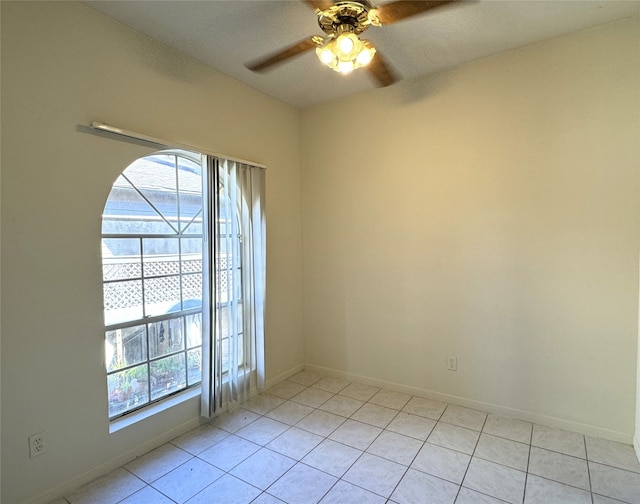 unfurnished room with ceiling fan, light tile patterned floors, and a wealth of natural light