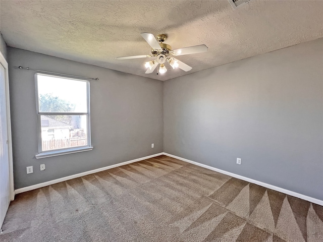 carpeted empty room with ceiling fan and a textured ceiling