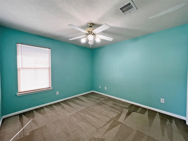 carpeted empty room with ceiling fan and a textured ceiling