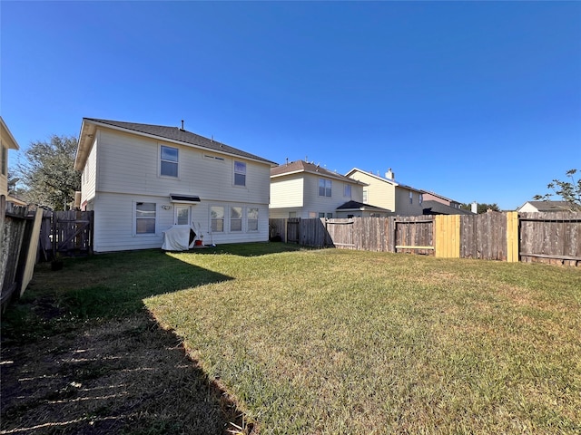 rear view of property with a lawn