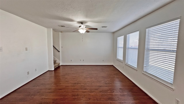 unfurnished room featuring ceiling fan, dark wood-type flooring, and a textured ceiling