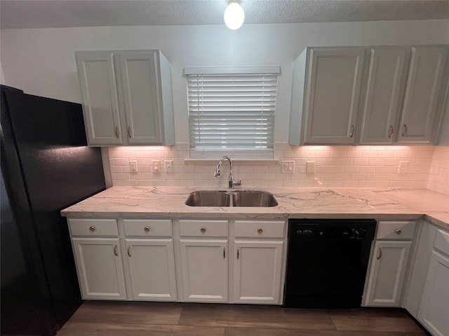 kitchen featuring white cabinetry, sink, black appliances, and light stone counters