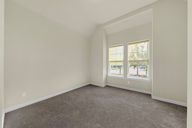 unfurnished room featuring carpet flooring and vaulted ceiling