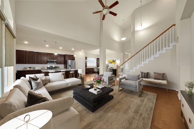 living room with ceiling fan, high vaulted ceiling, and hardwood / wood-style floors