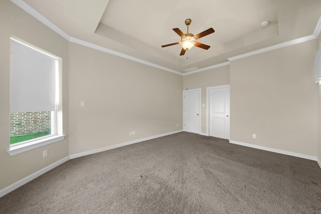 empty room featuring ornamental molding, a tray ceiling, and carpet floors