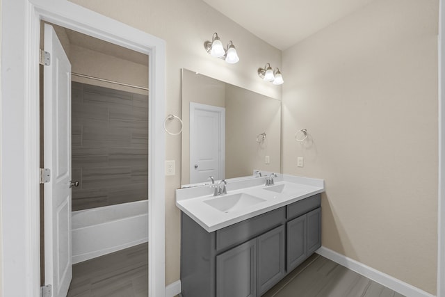 bathroom with vanity, tiled shower / bath, and hardwood / wood-style floors