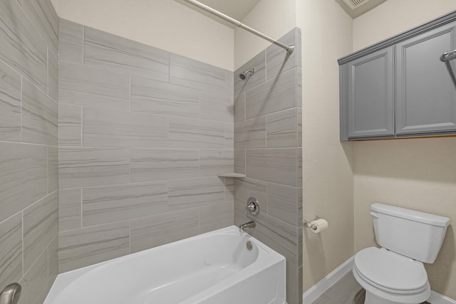 bathroom featuring toilet and tiled shower / bath