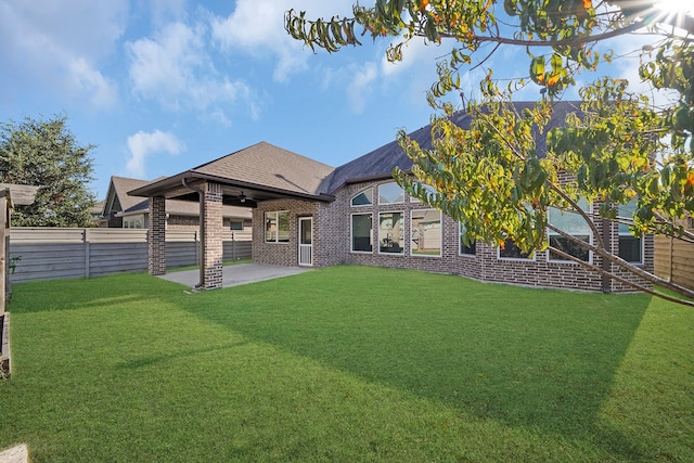 rear view of property with a yard, ceiling fan, and a patio area