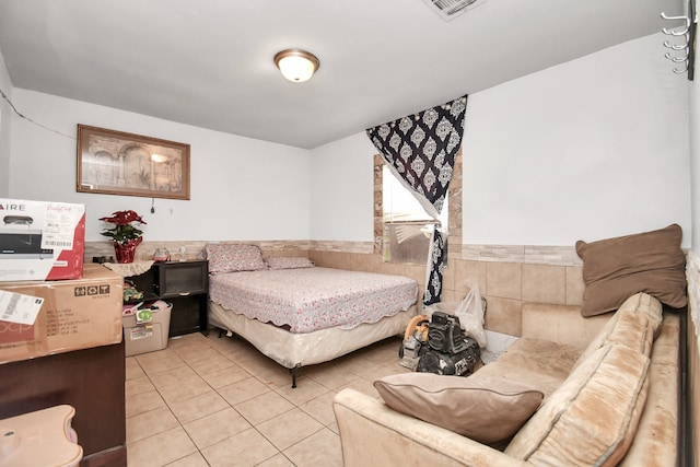 tiled bedroom featuring tile walls