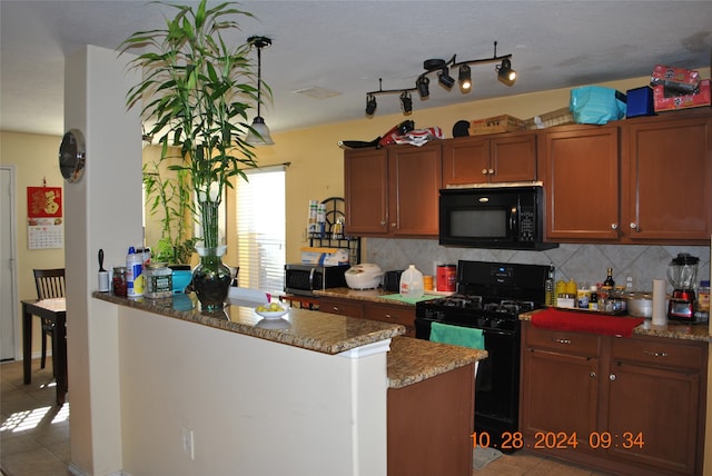 kitchen featuring tasteful backsplash, black appliances, stone counters, and light tile patterned floors