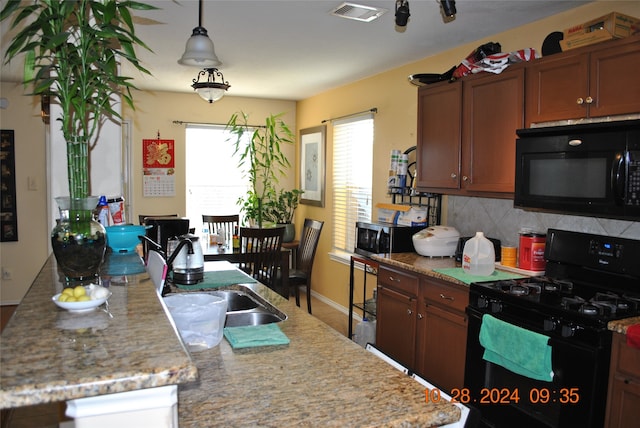 kitchen with decorative light fixtures, tasteful backsplash, black appliances, and sink