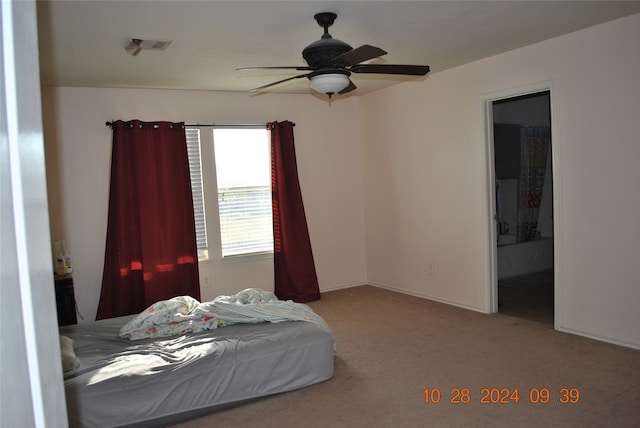 carpeted bedroom featuring connected bathroom and ceiling fan