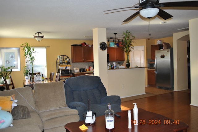 living room featuring dark wood-type flooring and ceiling fan