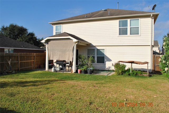 back of property with a patio area and a lawn