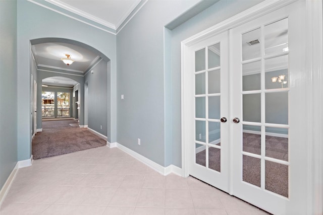 hallway featuring french doors, light colored carpet, and ornamental molding