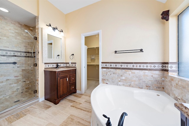 bathroom with vanity, tile walls, and independent shower and bath