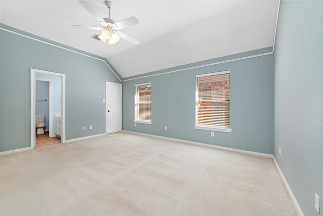 unfurnished bedroom with ensuite bathroom, ceiling fan, light colored carpet, and lofted ceiling