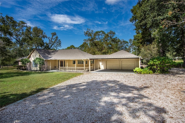 ranch-style home featuring a garage, a front lawn, covered porch, and driveway
