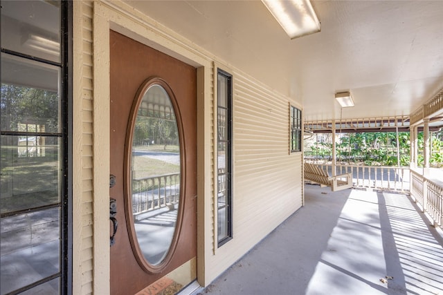 view of exterior entry featuring covered porch