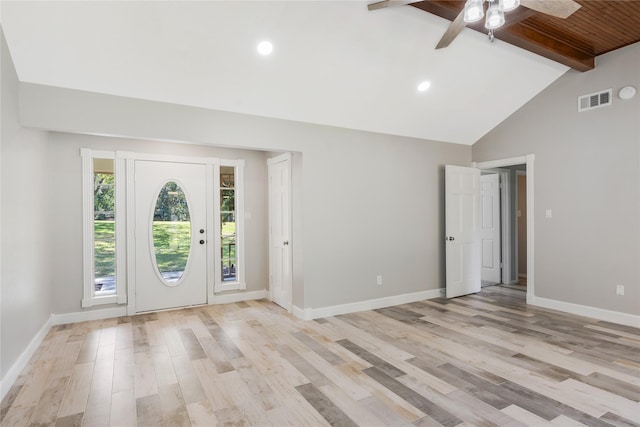 entryway featuring a ceiling fan, visible vents, baseboards, beamed ceiling, and light wood-style floors