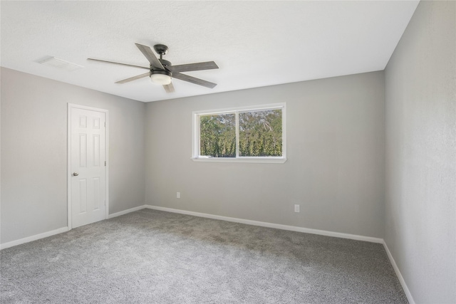carpeted empty room with baseboards and a ceiling fan