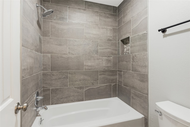 bathroom with toilet and tiled shower / bath combo