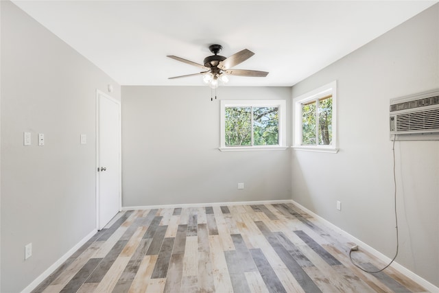 unfurnished bedroom with light hardwood / wood-style flooring, a wall mounted AC, and ceiling fan