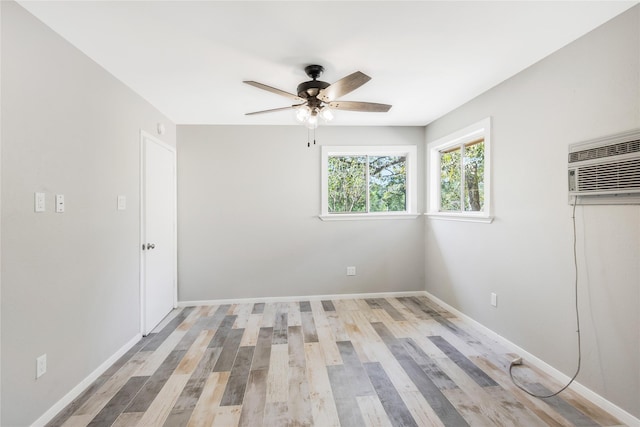 unfurnished bedroom featuring baseboards, a wall mounted AC, a ceiling fan, and light wood finished floors