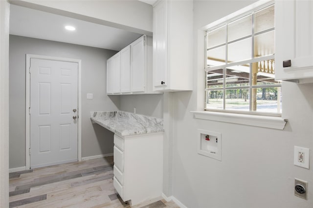 clothes washing area featuring cabinet space, washer hookup, light wood-style flooring, electric dryer hookup, and baseboards