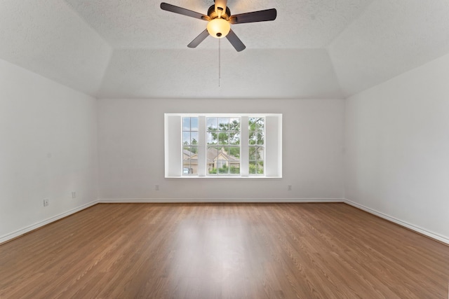 interior space featuring lofted ceiling, ceiling fan, wood-type flooring, and a textured ceiling