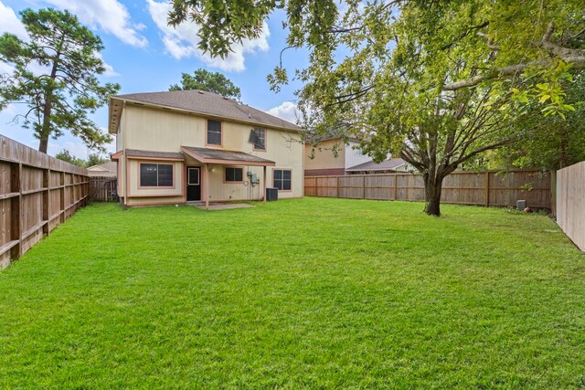 back of property featuring cooling unit and a lawn