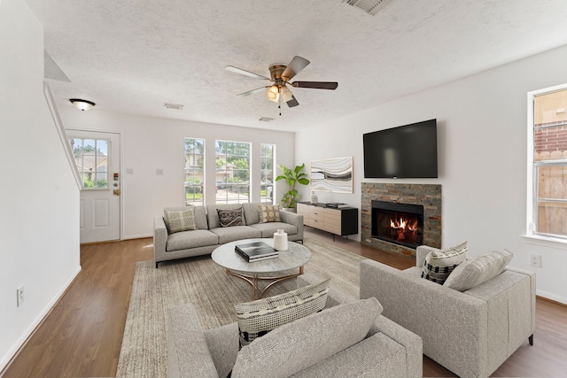 living room featuring a textured ceiling, wood-type flooring, and a healthy amount of sunlight