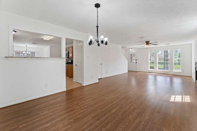 unfurnished living room with ceiling fan with notable chandelier, hardwood / wood-style floors, and a textured ceiling