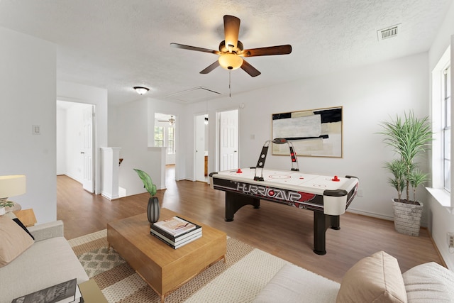 rec room featuring wood-type flooring and a textured ceiling