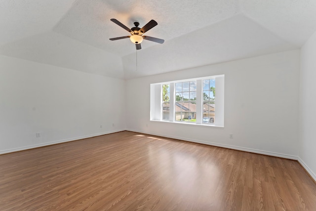 interior space with ceiling fan, vaulted ceiling, a textured ceiling, and light wood-type flooring