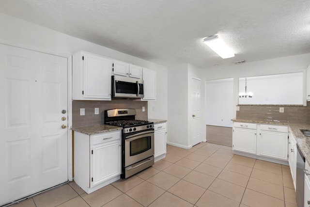 kitchen with white cabinetry, appliances with stainless steel finishes, and light tile patterned flooring