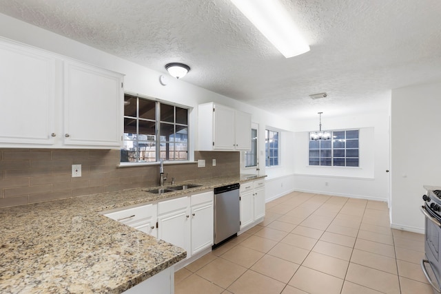 kitchen with sink, appliances with stainless steel finishes, light stone countertops, white cabinets, and decorative light fixtures