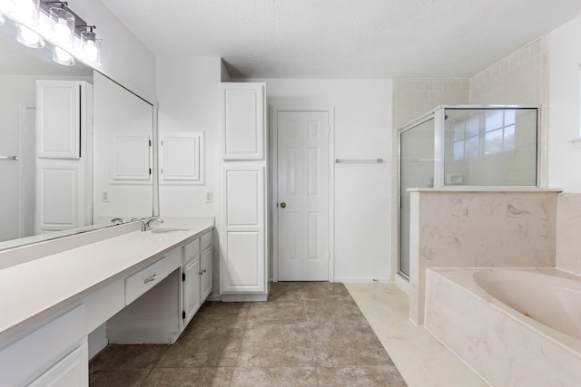 bathroom with vanity, independent shower and bath, and a textured ceiling