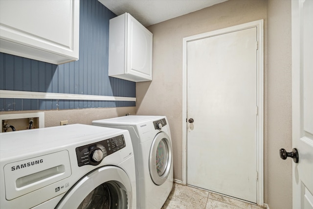 washroom with cabinets, washing machine and clothes dryer, and light tile patterned floors