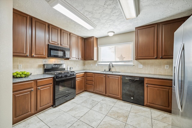 kitchen with a textured ceiling, black appliances, sink, and tasteful backsplash