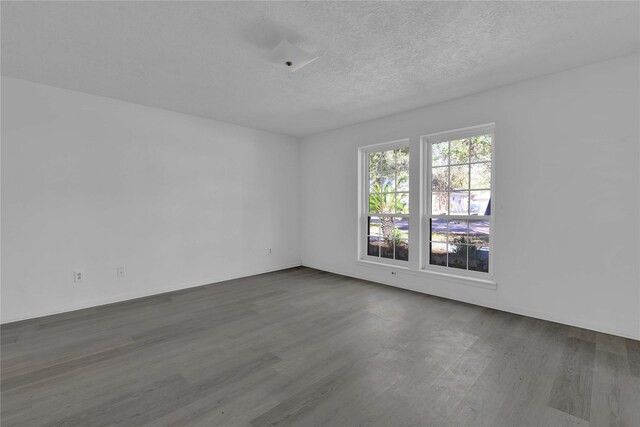 spare room with hardwood / wood-style floors and a textured ceiling