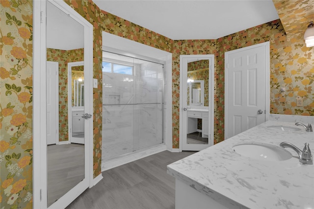 bathroom featuring vanity, a shower with shower door, and wood-type flooring