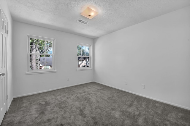 carpeted empty room featuring a textured ceiling