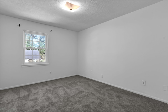 carpeted empty room featuring a textured ceiling