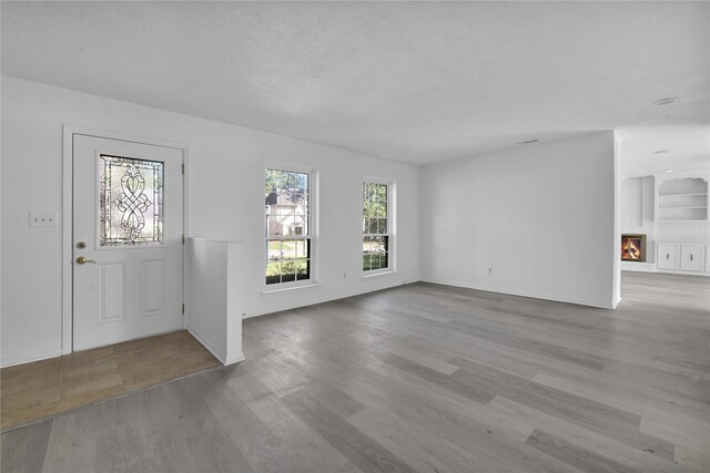 entrance foyer with light hardwood / wood-style floors and a textured ceiling