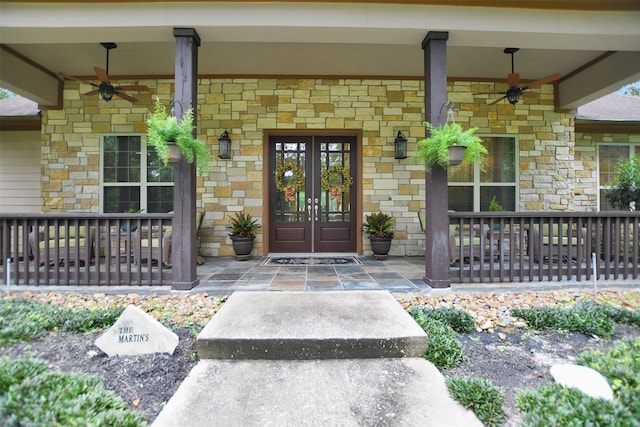 view of exterior entry featuring french doors and a porch